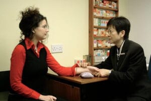 Trainees taking the pulse in the TCM Acupuncture Clinic to help make a diagnosis